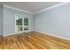 A serene bedroom with hardwood floors, neutral walls, and a large window with backyard view at 2001 Towne Lake W Hls, Woodstock, GA 30189