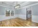 Refined dining space featuring hardwood floors, tray ceilings, and a stylish pendant light fixture at 2001 Towne Lake W Hls, Woodstock, GA 30189