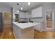 Well-lit kitchen features stainless appliances, a large island, and herringbone backsplash at 2001 Towne Lake W Hls, Woodstock, GA 30189