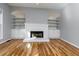 Cozy living room featuring a fireplace with custom shelving and hardwood floors throughout at 2001 Towne Lake W Hls, Woodstock, GA 30189