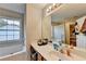 Well-lit bathroom featuring vanity with storage, bathtub with shower, and window for natural light at 1171 Pine Acre Dr, Sugar Hill, GA 30518