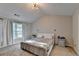 Bright bedroom features vaulted ceiling, neutral walls, carpet flooring, and natural light through window at 1171 Pine Acre Dr, Sugar Hill, GA 30518