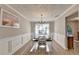 Formal dining room with wood floors, white wainscoting, and a chandelier over the dining table at 1171 Pine Acre Dr, Sugar Hill, GA 30518