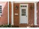 Classic brick home featuring a white front door, pillars, and tasteful exterior lighting at 3448 Paces Ferry Cir, Smyrna, GA 30080