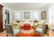 Cozy living room with an elegant area rug, a comfortable white sofa, a bold red ottoman, and classic decor at 3448 Paces Ferry Cir, Smyrna, GA 30080