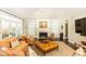 Well-lit living room featuring a fireplace, a ceiling fan, plenty of natural light, and comfortable orange and beige decor at 3448 Paces Ferry Cir, Smyrna, GA 30080