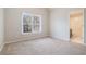 Comfortable bedroom featuring neutral carpeting and a bright sunny window. Adjoining bathroom at 3502 Crown Peak Ct, Suwanee, GA 30024