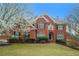 Charming red brick two-story home with manicured lawn and mature landscaping at 3502 Crown Peak Ct, Suwanee, GA 30024