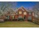 Brick two-story home with a manicured front yard and blooming tree at 3502 Crown Peak Ct, Suwanee, GA 30024