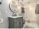 Bathroom with gray vanity, marble countertop, round mirror and modern lighting fixtures at 4325 Cody Ct, Cumming, GA 30040