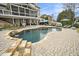 A luxurious pool with a stone waterfall feature, surrounded by patio seating and lush landscaping at 4325 Cody Ct, Cumming, GA 30040