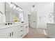 Bright bathroom featuring dual sinks, white cabinetry, and a well-lit vanity mirror at 900 Melrose Park Pl, Lawrenceville, GA 30044