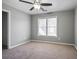 A carpeted bedroom featuring a ceiling fan and a window that allows natural light at 1278 Crown Ter, Marietta, GA 30062