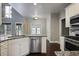 Well-lit kitchen with granite counters, stainless steel dishwasher, and dark hardwood flooring at 1278 Crown Ter, Marietta, GA 30062