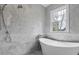 Bathroom features a soaking tub, marble tile, and a large window at 239 E Wesley Ne Rd, Atlanta, GA 30305