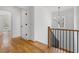 Hallway with wooden floor, with iron decorative stair railing and decorative light fixture at 239 E Wesley Ne Rd, Atlanta, GA 30305