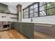 Modern kitchen featuring stainless steel appliances, dark green cabinets, and hardwood floors at 239 E Wesley Ne Rd, Atlanta, GA 30305