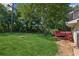 Expansive backyard featuring lush lawn, mature trees, and a charming red deck at 1231 Sanden Ferry Dr, Decatur, GA 30033