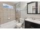 This renovated bathroom features neutral tiles, a shower-over-tub, and a vanity with extra storage space at 1231 Sanden Ferry Dr, Decatur, GA 30033