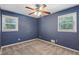 This blue bedroom boasts natural light from two windows, features plush carpet, and a ceiling fan at 1231 Sanden Ferry Dr, Decatur, GA 30033