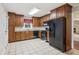 Well-lit kitchen featuring granite countertops, wood cabinets, and black appliances at 1231 Sanden Ferry Dr, Decatur, GA 30033