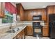 Kitchen area featuring stainless steel sink, black appliances, and granite countertops at 1231 Sanden Ferry Dr, Decatur, GA 30033