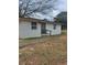 A quaint single story home shows a side entrance and narrow walkway with simple landscaping at 136 Tye St, Stockbridge, GA 30281