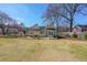 Large backyard featuring a deck with patio furniture, mature trees, and green grass on a sunny day at 2982 N Main Nw St, Kennesaw, GA 30144