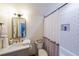 Well-lit bathroom with updated sink, framed mirror, and tub with tiled walls and neutral colors at 2982 N Main Nw St, Kennesaw, GA 30144