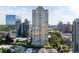 An aerial view of a high-rise condo building surrounded by modern buildings, trees, and lush landscaping at 3445 Stratford Ne Rd # 1605, Atlanta, GA 30326