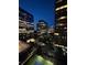 Night view of modern high-rise buildings featuring illuminated windows, city street, and a tennis court at 3445 Stratford Ne Rd # 1605, Atlanta, GA 30326