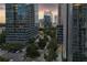 View of the cityscape with modern buildings, green trees, and an organized circular parking area for residents at 3445 Stratford Ne Rd # 1605, Atlanta, GA 30326