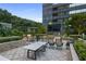 Outdoor dining and grilling area with table, chairs, grill and lush green landscaping at 3445 Stratford Ne Rd # 1605, Atlanta, GA 30326