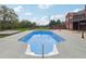 Backyard exterior featuring a long pool with expansive patio and green backdrop at 2984 Berry Rd, Loganville, GA 30052