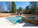 Inviting backyard pool with stone accents, spa, and outdoor fireplace at 330 Todwick Dr, Roswell, GA 30075