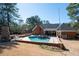 Aerial view of the refreshing backyard pool area with outdoor fireplace and lush landscaping at 330 Todwick Dr, Roswell, GA 30075