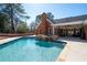 Beautiful pool with stone waterfall feature, surrounded by patio and lush landscaping at 330 Todwick Dr, Roswell, GA 30075