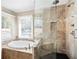 Modern bathroom featuring a glass-enclosed shower, soaking tub, tile walls, and natural light at 330 Todwick Dr, Roswell, GA 30075