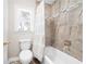 Bathroom featuring tile walls, a window with blinds, and a toilet with a shower and bathtub at 330 Todwick Dr, Roswell, GA 30075