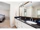 Elegant bathroom vanity with dual sinks, black countertops, white cabinets, and a large framed mirror at 330 Todwick Dr, Roswell, GA 30075