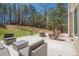 Spacious backyard patio with outdoor seating, a fire pit, and lush landscaping at 9225 Wilshire Pl, Cumming, GA 30028