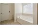 Bright bathroom with a soaking tub and a window for natural light at 9225 Wilshire Pl, Cumming, GA 30028