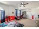 Bright bedroom with a ceiling fan, shelving, and entertainment center, offering a playful and functional space at 9225 Wilshire Pl, Cumming, GA 30028