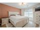 Bright bedroom featuring neutral decor, complemented by an ensuite and side chair, creating a calming atmosphere at 9225 Wilshire Pl, Cumming, GA 30028