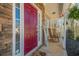 Inviting covered front porch with a red door, stone accents, hanging plants, and rocking chairs at 9225 Wilshire Pl, Cumming, GA 30028