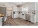 Bright kitchen with stainless steel appliances, white cabinetry, and laminate flooring at 9225 Wilshire Pl, Cumming, GA 30028