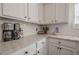 Close up on the kitchen's white cabinets, marble countertops, and stainless steel appliances at 9225 Wilshire Pl, Cumming, GA 30028