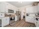 Bright kitchen features white cabinets, stainless steel appliances, and hardwood floors at 9225 Wilshire Pl, Cumming, GA 30028