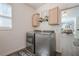 Clean and well-lit laundry room with modern washer and dryer units and laminate flooring at 9225 Wilshire Pl, Cumming, GA 30028