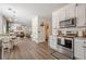 Open floor plan with hardwood floors, white walls, and stainless steel appliances at 9225 Wilshire Pl, Cumming, GA 30028